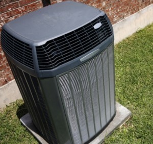 heat pump in grass outside of brick house