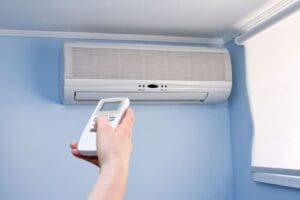 Person using remote to control ductless mini-split