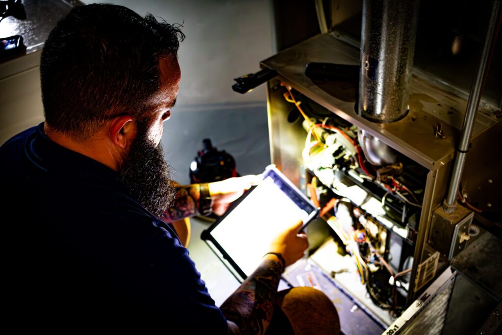 HVAC technician for Classic Aire Care inspecting a furnace
