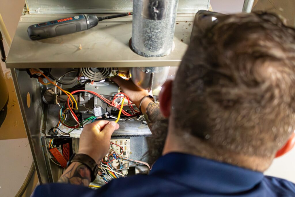 HVAC technician for Classic Aire Care repairing a furnace
